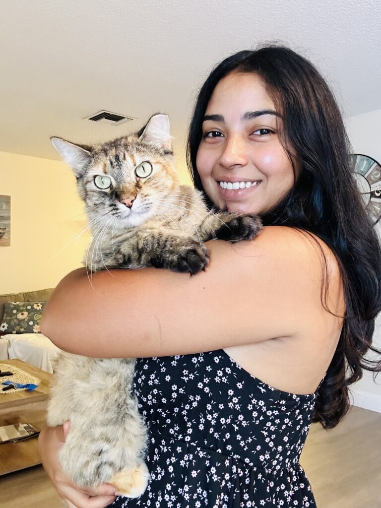 Pet sitter holding a fluffy tabby cat, showcasing a caring and friendly pet care service.